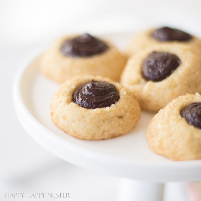 These wonderful Chocolate Thumbprint Cookies are rolled in turbinado sugar for a sweet crunchy outer layer. The chocolate ganache is a perfect pairing to the awesome little cookie. Baking | Cookie Recipe | Recipes | Desserts | Cookie | Chocolate Ganache | Cookies | Homemade Cookies | Best Cookies | Chocolate Cookie