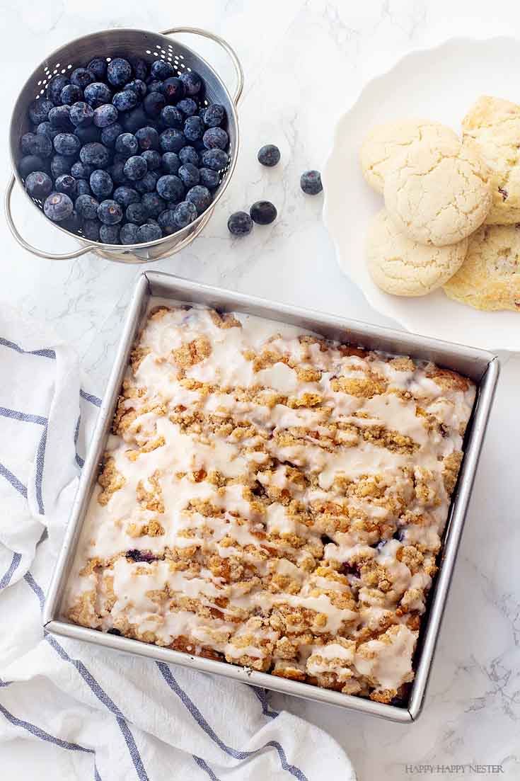 This dessert is The Best Blueberry Buckle Cake Recipe and is sure the perfect side to a cup of coffee or tea. Serve it as a dessert or as a morning blueberry coffee cake. This easy recipe makes an impressive cake with the crumble and delicious icing. #cake #coffeecake #blueberrydessserts #blueberries #desserts #pastry 