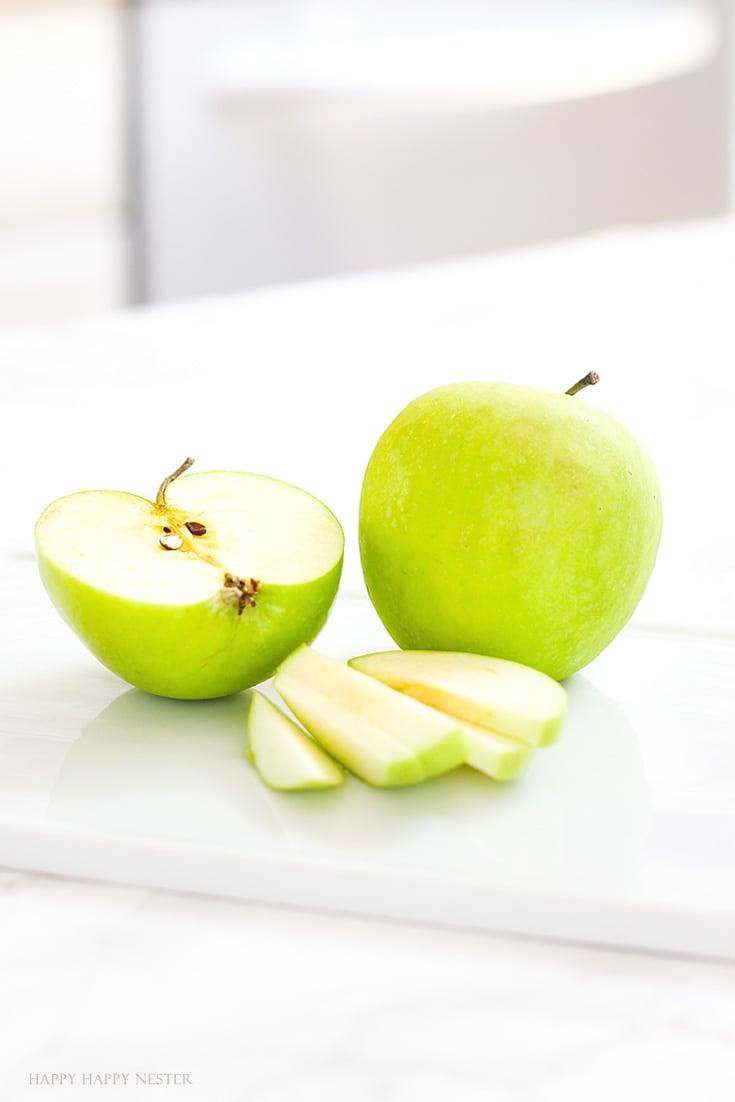 Green apples sliced and sitting on a white platter