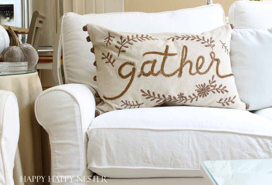 pillow with the words gather embroidered on it.