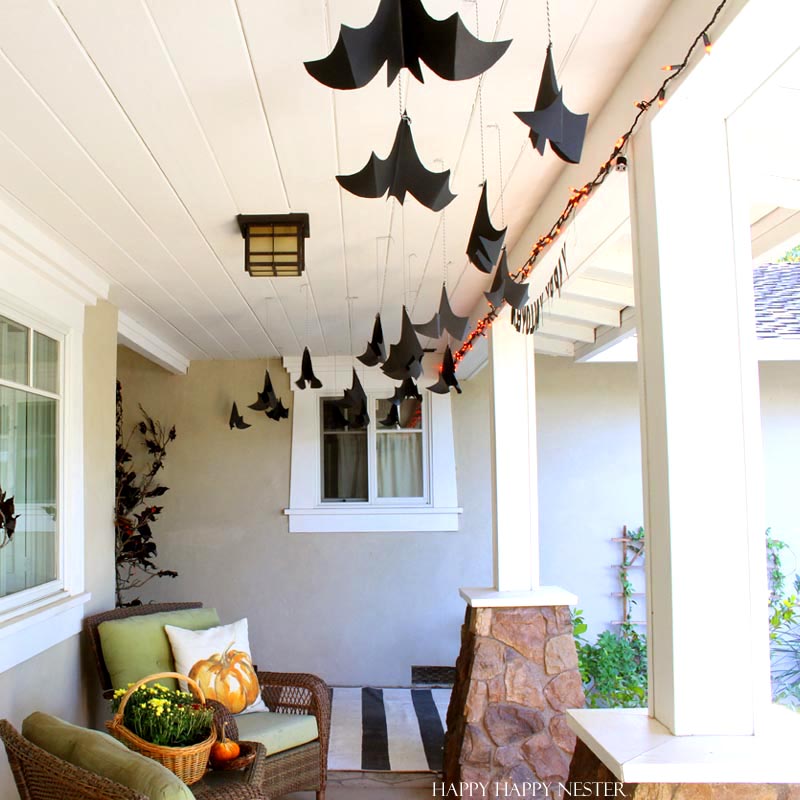 paper bats hanging from the white ceiling on a porch