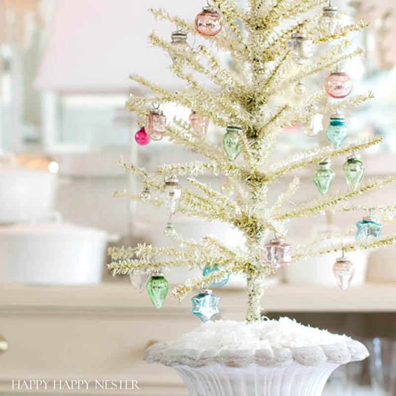 This is an easy way to make a Feather Tree. You take a tinsel tree and give it a good haircut. Then you add a bit of chalk paint to make it vintage like.