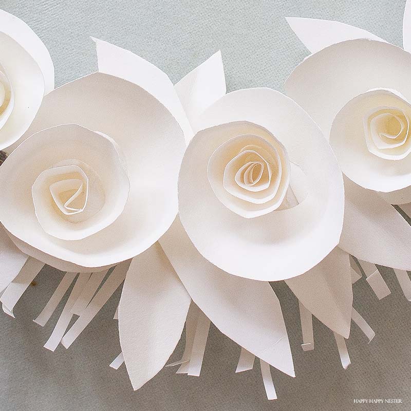 If you want a beautiful white paper wreath that will go with any decor, then you will love my latest paper craft. This paper flower project isn't that difficult, and the result is a beautiful year-round wreath. Make a few rosette paper flowers and leaves, and that's it. #crafts #papercrafts #diy #paper #paperflowers