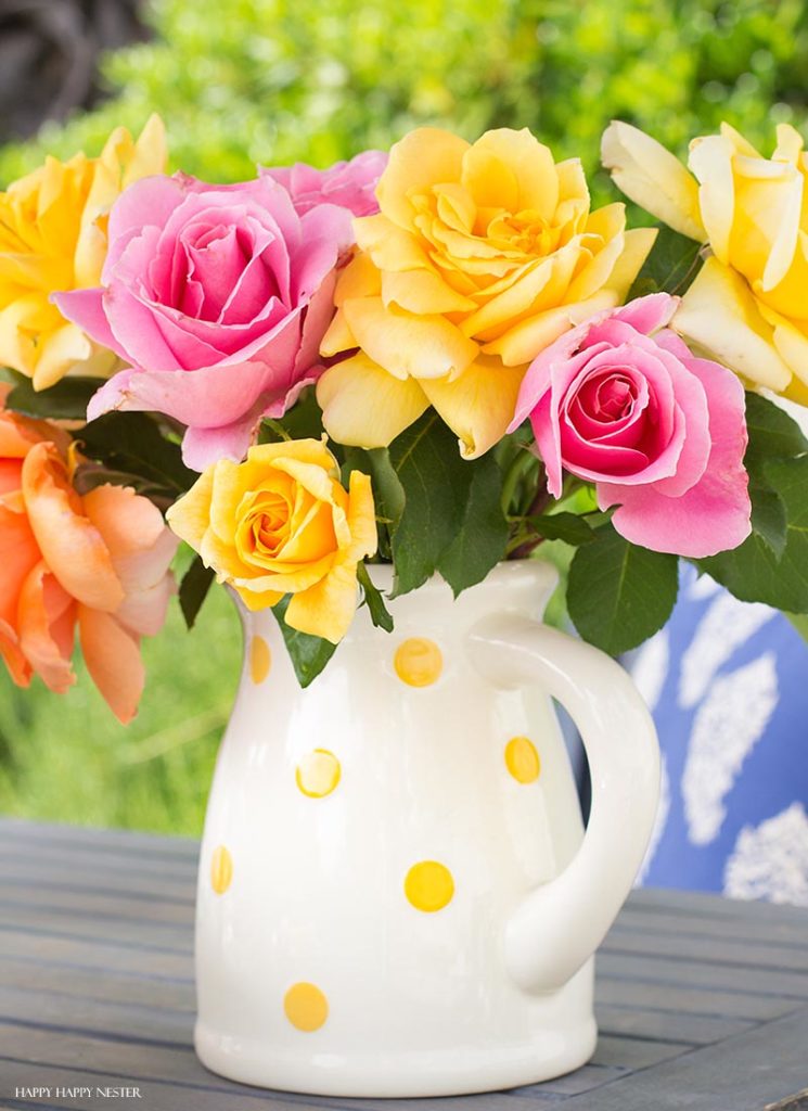 pink and yellow roses in a white pitcher