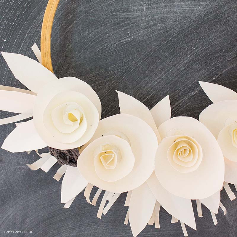If you want a beautiful white paper wreath that will go with any decor, then you will love my latest paper craft. This paper flower project isn't that difficult, and the result is a beautiful year-round wreath. Make a few rosette paper flowers and leaves, and that's it. #crafts #papercrafts #diy #paper #paperflowers