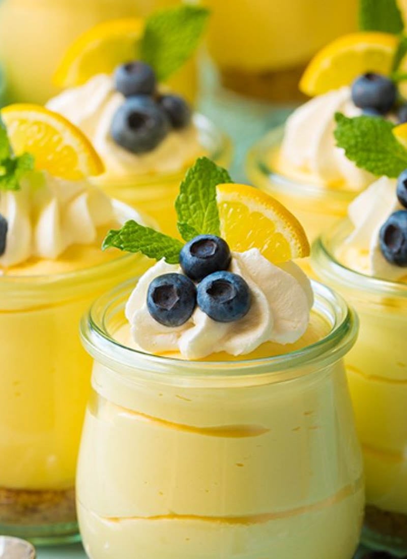 lemon curd topped with whip cream and blueberries in little glass containers