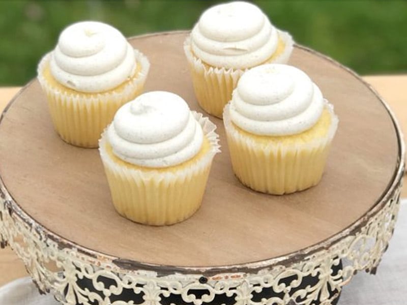 4 lemon cupcakes on white cakestand