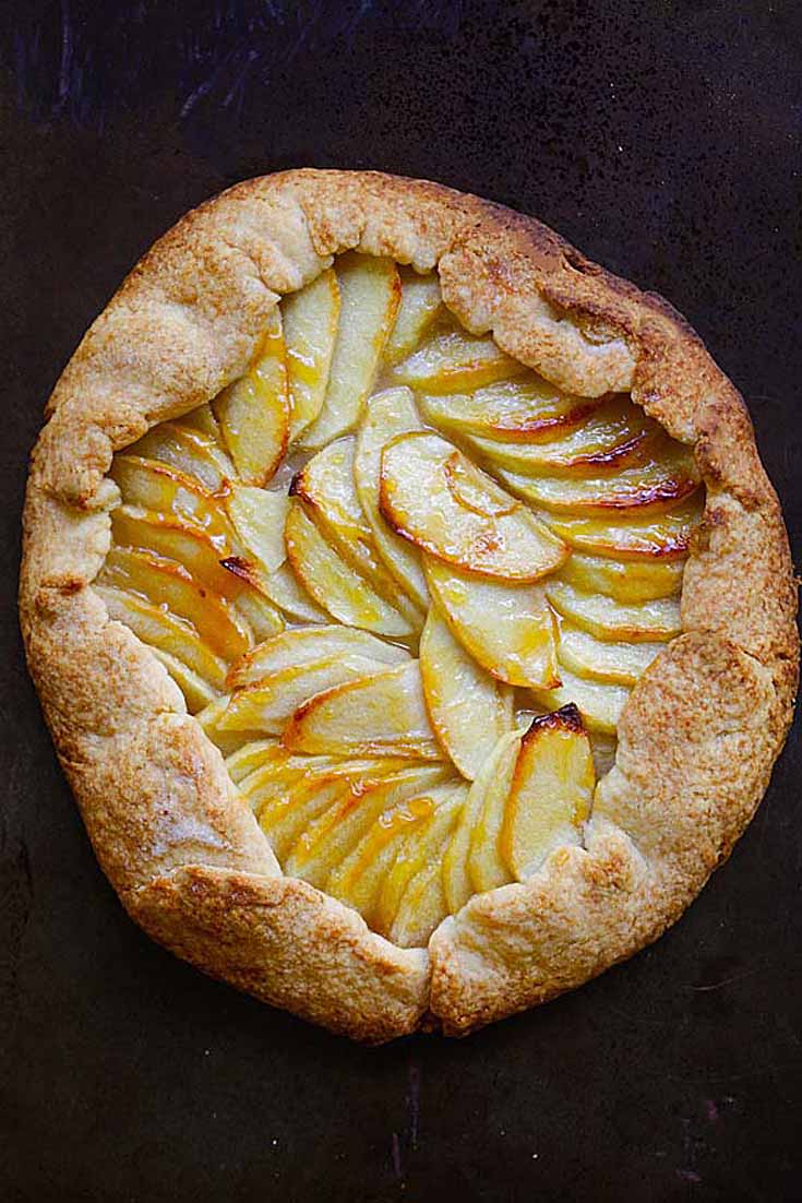 rustic apple tart with outer crust. Tart is on a black background