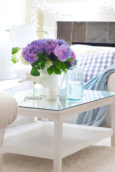 white living room with purple hydrangeas on a coffee table