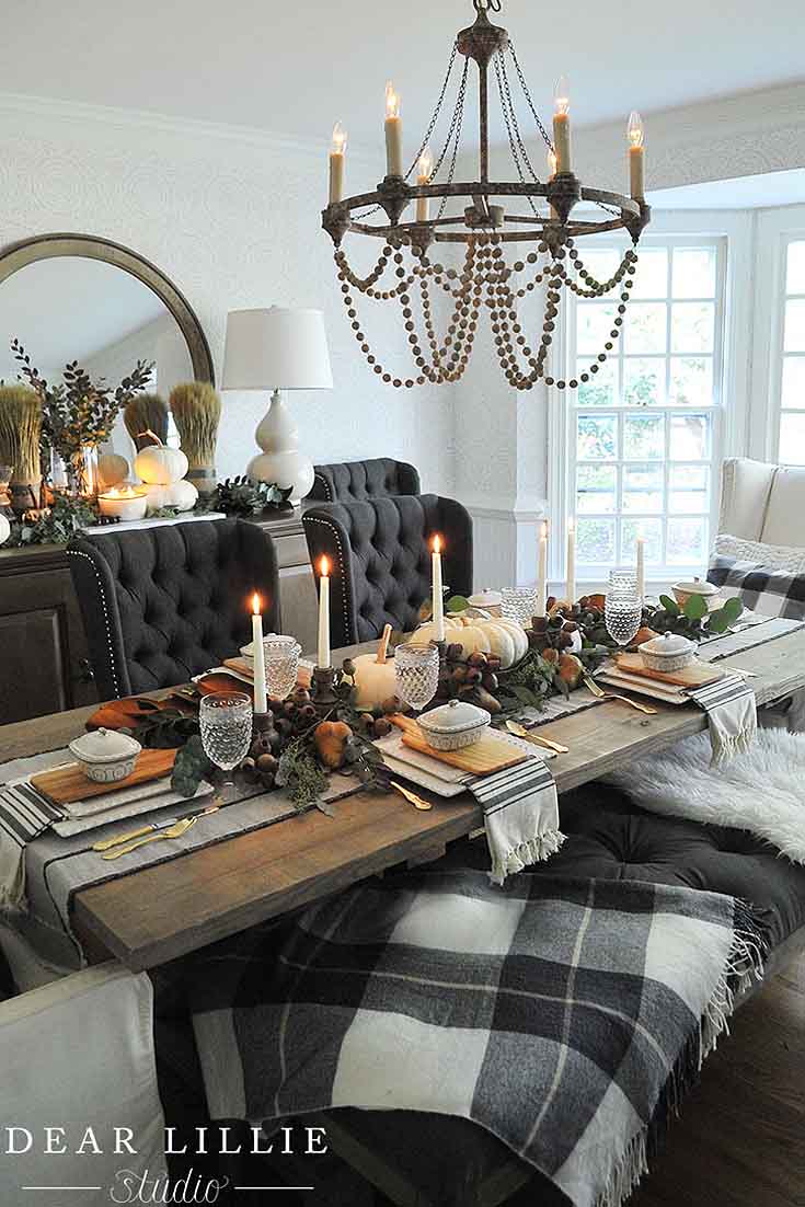 a fall table with black chairs and green and gold leaves