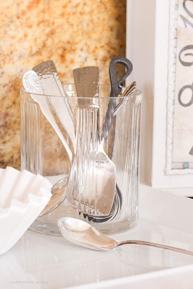 antique silver spoons in a glass container