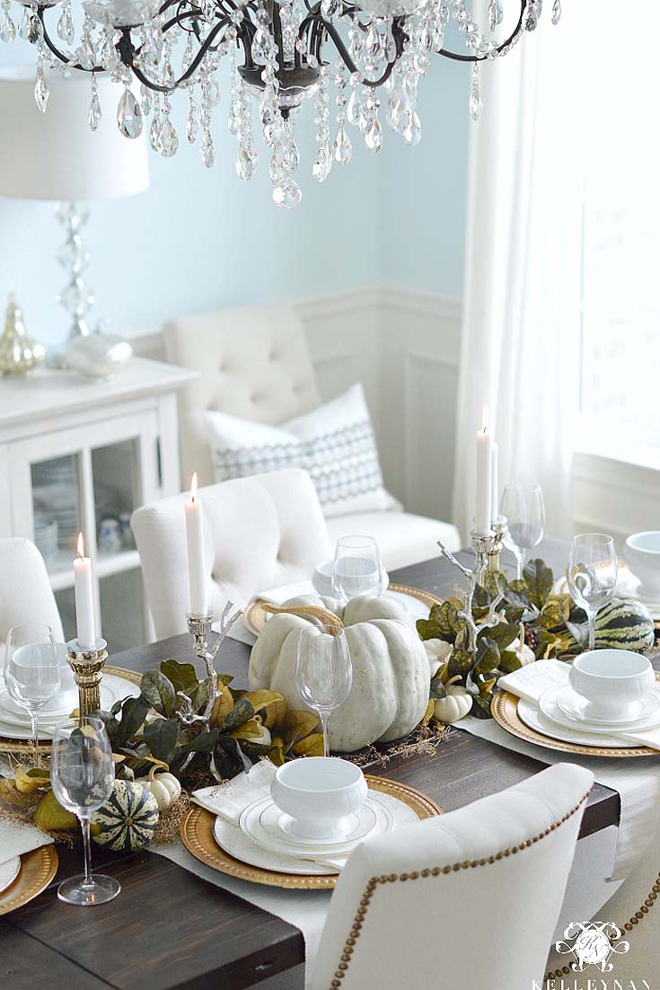 fall table with green leaves and white pumpkins