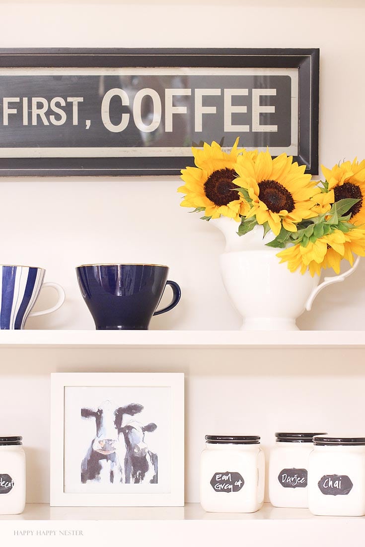 Yellow sunflowers and coffee mugs on a white kitchen shelf