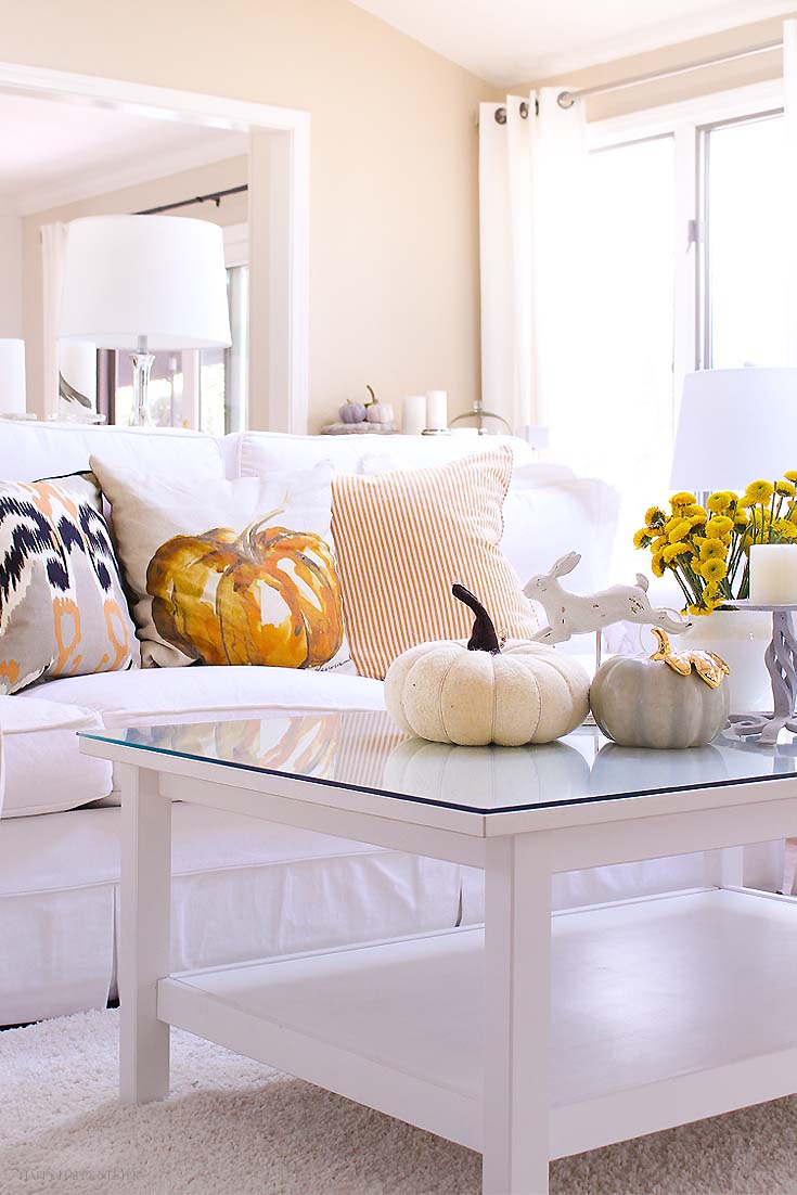 white living room with pumpkin on the coffee table