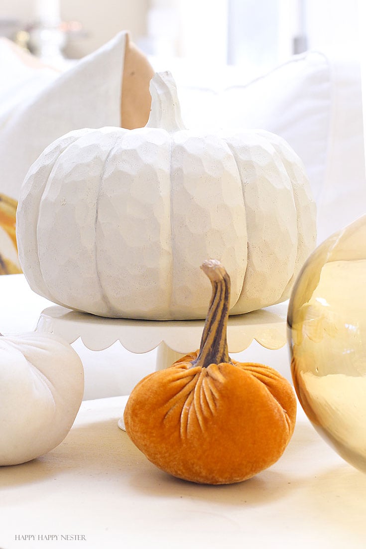 white pumpkin with two smaller pumpkins on a table