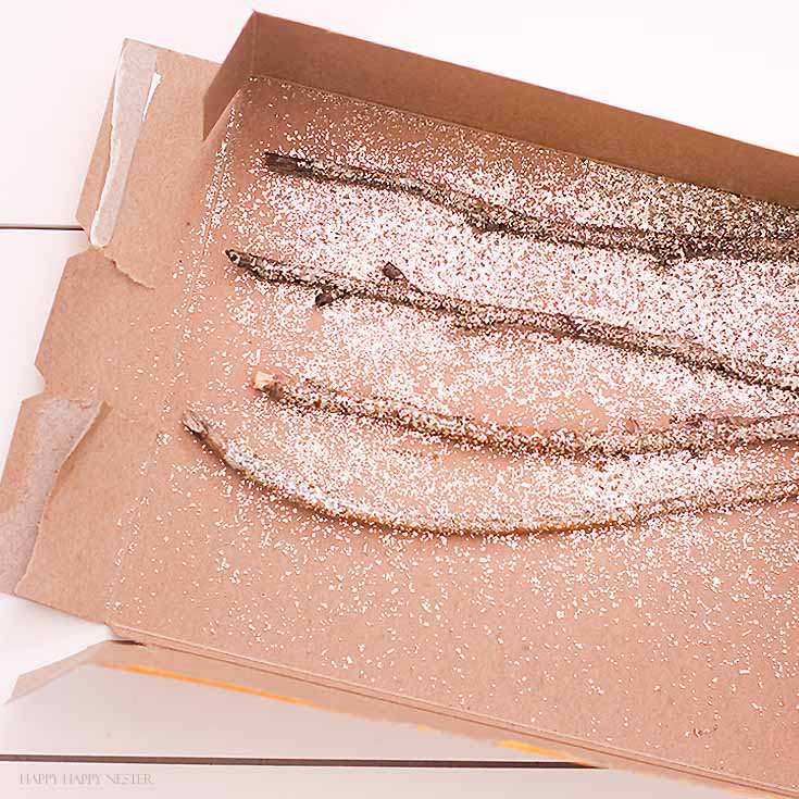 Twigs with glitter in a card board box