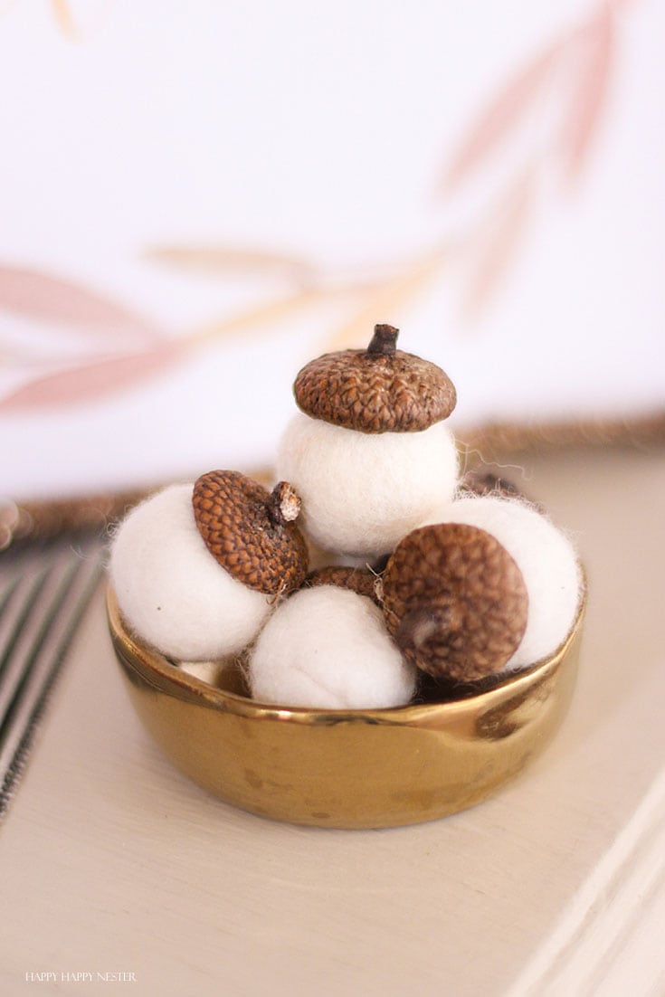 wool white acorns in a gold bowl
