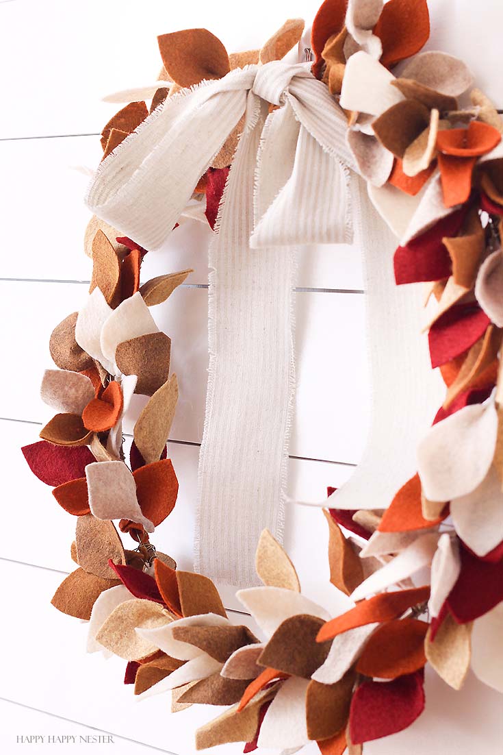 side shot of felted leaf wreath hanging on white wall