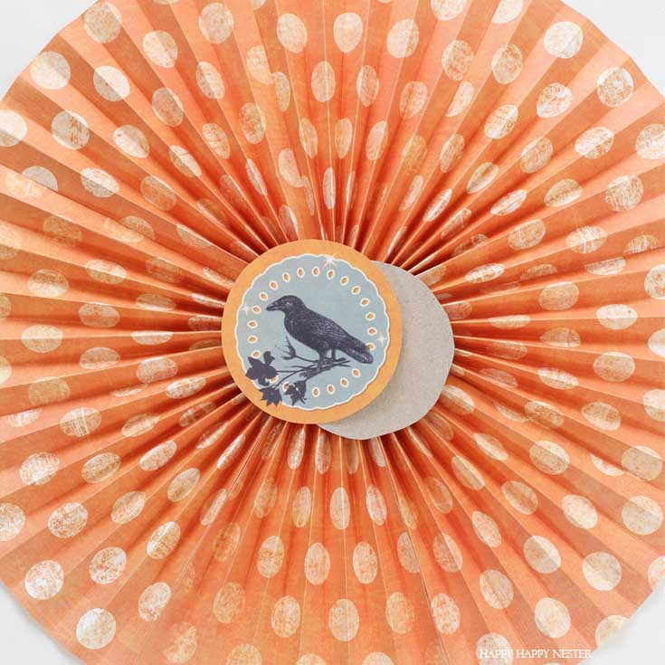 orange paper rosette with crow in center