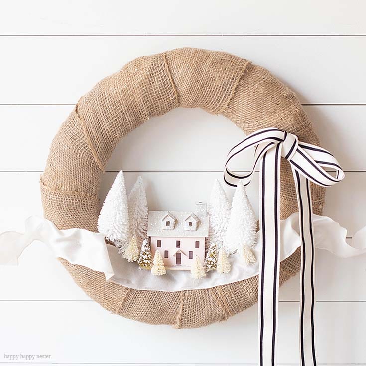 Make this DIY Christmas Village Wreath with homemade putz houses. Add some bottle brush trees, ribbon and you have a personal holiday wreath. | Crafts | Wreaths | Holiday Wreaths | Putz Houses | DIY Wreaths | DIY | Wreath Making | Cute Wreaths | Mini Village Houses | Homemade Wreaths | Martha Stewarts Village Wreath |