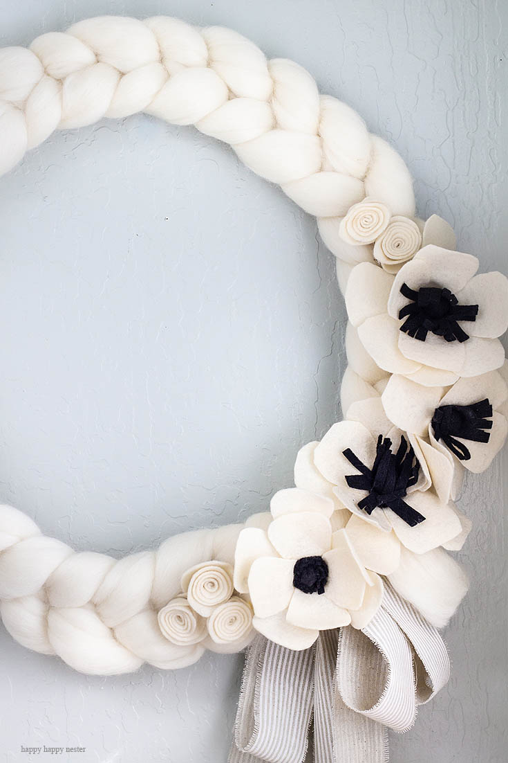 This white wreath is the perfect thing to brighten your home. Here is a quick and easy arm knitted wreath to chase your winter blues away! This wreath is so easy to arm knit, and you'll seriously love the results. I love how this bright wreath will look great all year long. Crafts | Arm Knit | Arm Knit Wreath | Wreaths | Wreath DIY | Craft Tutorial | Arm Knit Project | Wreath