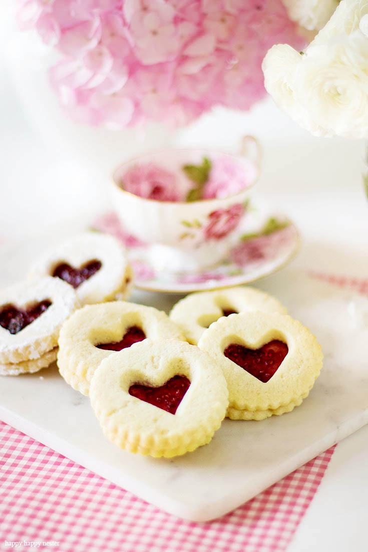 These delicious cookies are great year round. This Raspberry Filled Valentine's Heart Cookie Recipe is the perfect dessert for a dinner or a party. Give them away as a Valentine's Day gift for a friend. Sprinkle them with powdered sugar for an extra-amazing sugar cookie. Cookie | Baking | Valentine's Day Treats | Cookie Recipe | Raspberry Filled Cookies