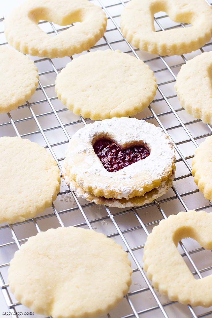 This raspberry filled valentine's heart cookie is the perfect dessert for a dinner or a party. Give them away as a Valentine's Day gift for a friend. Sprinkle them with powdered sugar for an extra-amazing sugar cookie. Cookie | Baking | Valentine's Day Treats | Cookie Recipe | Raspberry Filled Cookies