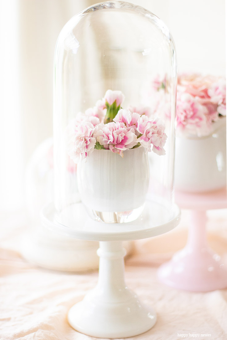 Add glass cloches on cake stands. Cake stands are easy ways to decorate a table or your home. I have gathered some Cute Ways to Use a Cake Stand that I'm sure you'll love. You can use them for the holidays or even a wedding reception. They add drama and interest because of their styles and heights. #cakestands #decorating #weddings #flowers #decor