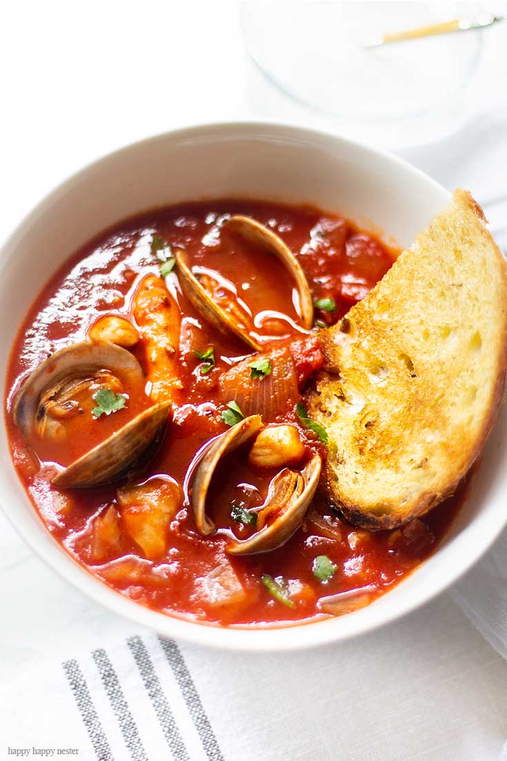 For a cold winter night or a warm summer dinner, this Cioppino is a perfect meal. Our family favorite Yummy Seafood Stew Recipe is the best San Francisco style Cioppino. Make this the evening before so all the flavors are their best. This is the best Cioppino recipe since it includes wine and sugar to balance and mellow the acid from the tomatoes. #cioppino #italiandinner #soup #fishstew