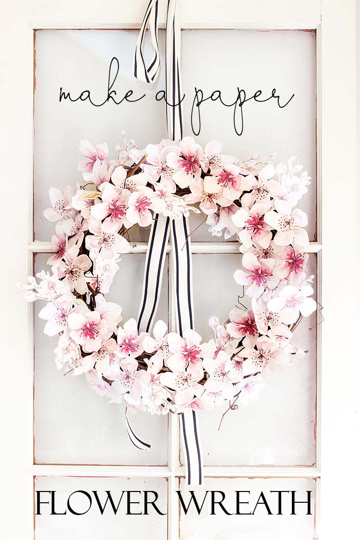 This easy How to Make a Paper Flower Wreath DIY is perfect for the spring. This wreath uses watercolor cherry blossoms that you cut out and glue to a grapevine wreath. It is a simple wreath that is beautiful and nice year round. The supplies include a wreath, paper, scissors, glue, and ribbon. #crafts #wreaths #spring