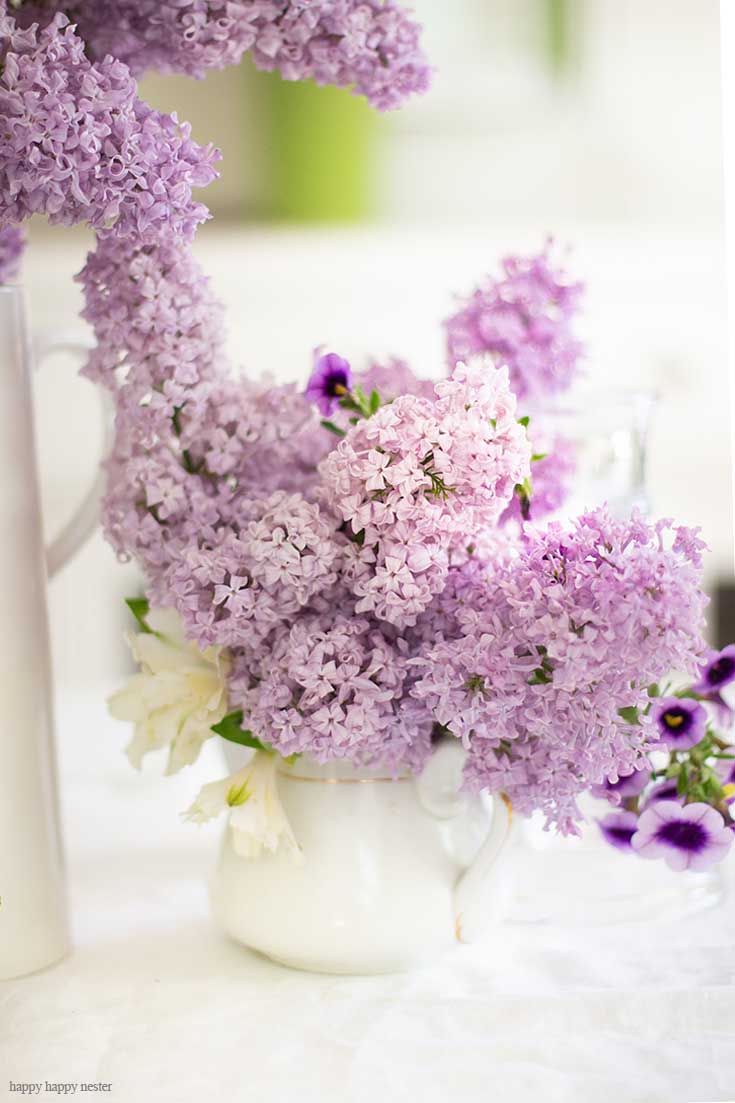 It doesn't take much to create a Beautiful Spring Table with Fresh Flowers. This spring table with fresh lilacs and other garden flowers is so easy to create. No need to spend much to style a fabulous spring table. #springtable #flowerbouquet #freshflowers #lilacs #lavendertable #decoratingwithlilacs #purplelilacs