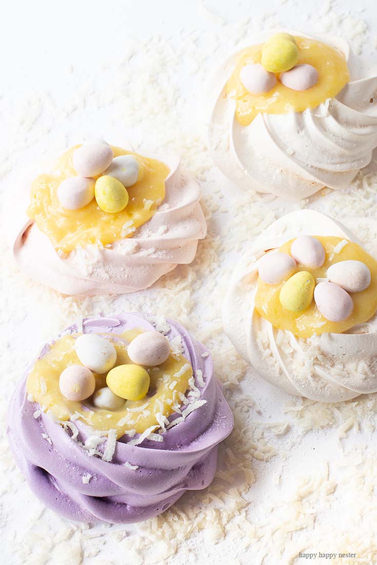 Love these easy and adorable pavlova nests. This Pavlova Recipe is so easy and the Mini Nests are so adorable. They are perfect for Easter, a spring dessert or year-round treat. Use different food colors to create cute fresh nests. Top the nests with lemon curd, whip cream, and Easter eggs. #baking #easter #desserts #easterdesserts #meringue #pavlova #lemoncurd