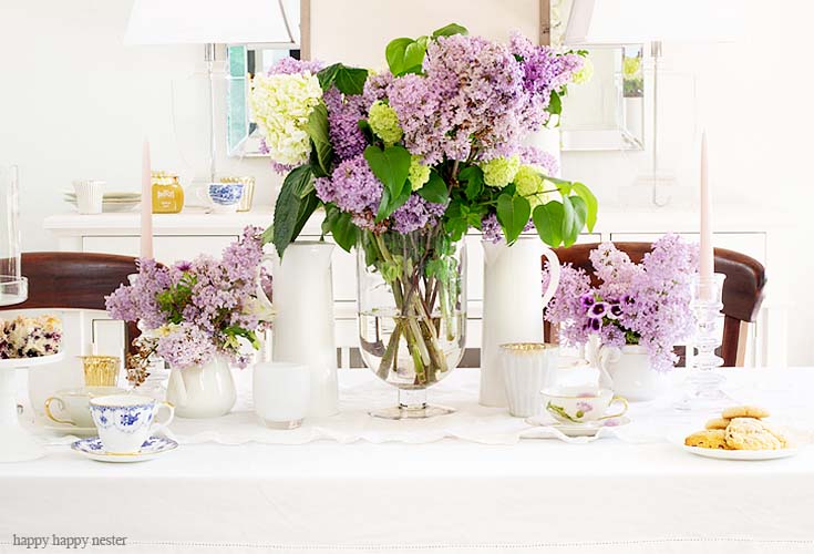 Here is an easy way to decorate your spring table. It doesn't take much to create a Beautiful Spring Table with Fresh Flowers. This spring table with fresh lilacs and other garden flowers is so easy to create. No need to spend much to style a fabulous spring table. #springtable #flowerbouquet #freshflowers #lilacs #lavendertable #decoratingwithlilacs #purplelilacs