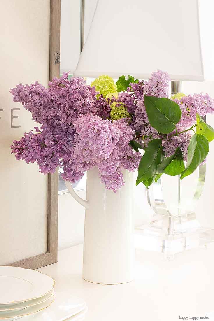 Placing lilacs in vases is the best way to decorate your home. It doesn't take much to create a Beautiful Spring Table with Fresh Flowers. This spring table with fresh lilacs and other garden flowers is so easy to create. No need to spend much to style a fabulous spring table. #springtable #flowerbouquet #freshflowers #lilacs #lavendertable #decoratingwithlilacs #purplelilacs