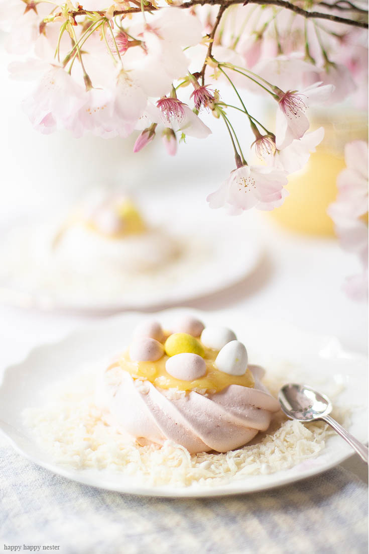 This Pavlova Recipe is so easy and the Mini Nests are so adorable. They are perfect for Easter, a spring dessert or year-round treat. Use different food colors to create cute fresh nests. Top the nests with lemon curd, whip cream, and Easter eggs. #baking #easter #desserts #easterdesserts #meringue #pavlova #lemoncurd