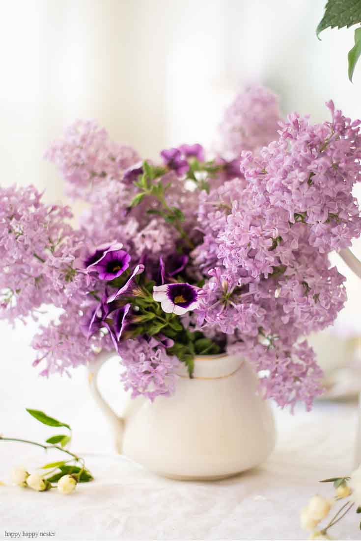 It doesn't take much to create a Beautiful Spring Table with Fresh Flowers. This spring table with fresh lilacs and other garden flowers is so easy to create. No need to spend much to style a fabulous spring table. #springtable #flowerbouquet #freshflowers #lilacs #lavendertable #decoratingwithlilacs #purplelilacs