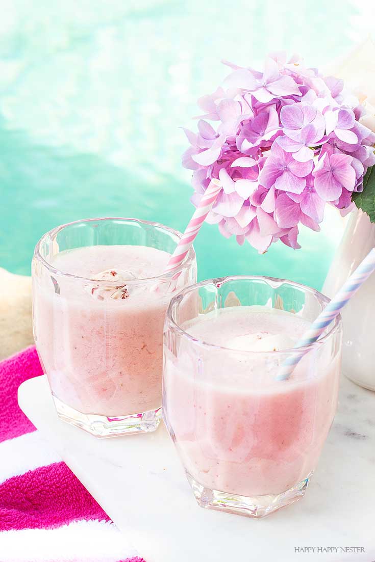 Yummy pink drink for summer entertaining. Get this delicious recipe that includes, coconut juice, strawberry ice cream, strawberries, bananas, and ginger ale. #summer #drinks, #recipes, #drinkrecipes, #cocktails