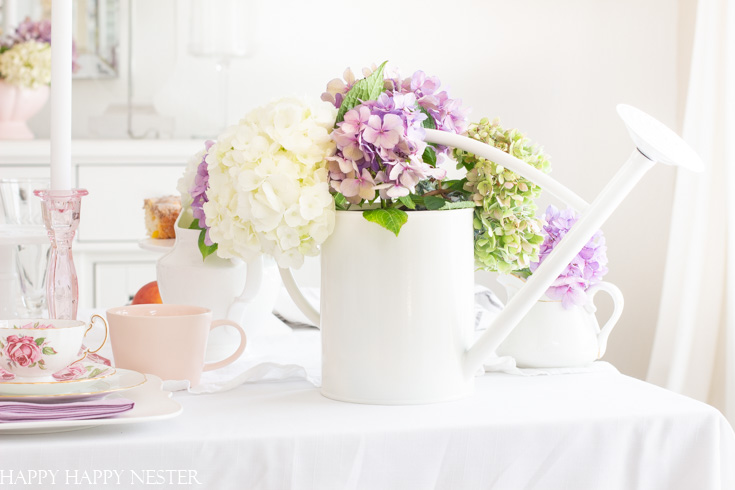 Create a gorgeous summer table decor with hydrangeas in just a few minutes. These summer garden flowers are the perfect addition to an easy summer table. Add a few white water cans as vases, and you have a fresh cute table decor. #summertable #hydrangeas #decor