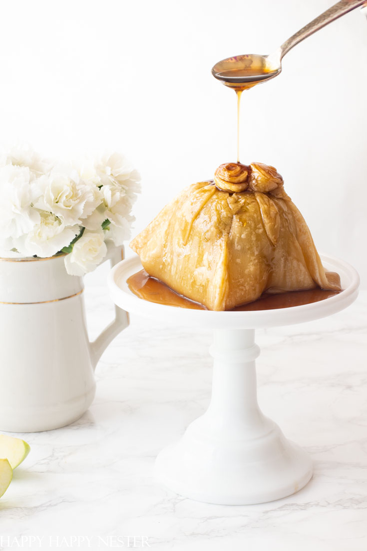 This apple recipe is simply amazing! The apple has sugared nuts inside and is topped with a pastry dough and caramel sauce. #dessert #appledumpling #appledesserts