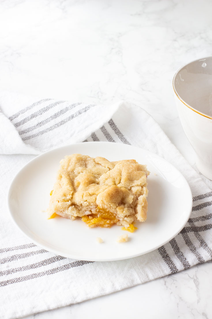 This Peach Cobbler with Almond Cookie Dough is a delightful and subtle blend of almond and peaches. It is a new twist to a summer dessert of fresh fruit. Add a dollop of vanilla ice cream, and it is the perfect way to end a summer meal. #peachcobbler #recipe #desserts #freshfruitrecipe