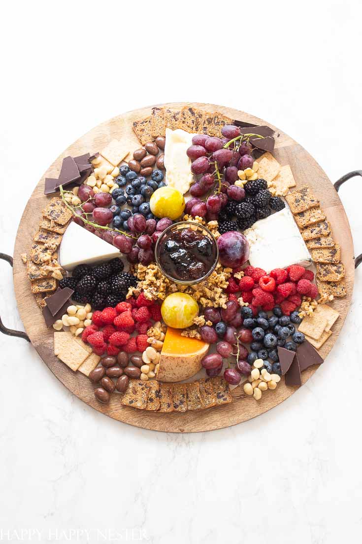 Need some Easy Appetizer Ideas for a Party, then you'll want to view this step by step tutorial. It shows how to build a fruit, cheese charcuterie board. This photo will be wooden round board with fruit, cheese and crackers. #appetizers #easyappetizers #charcuterieboard