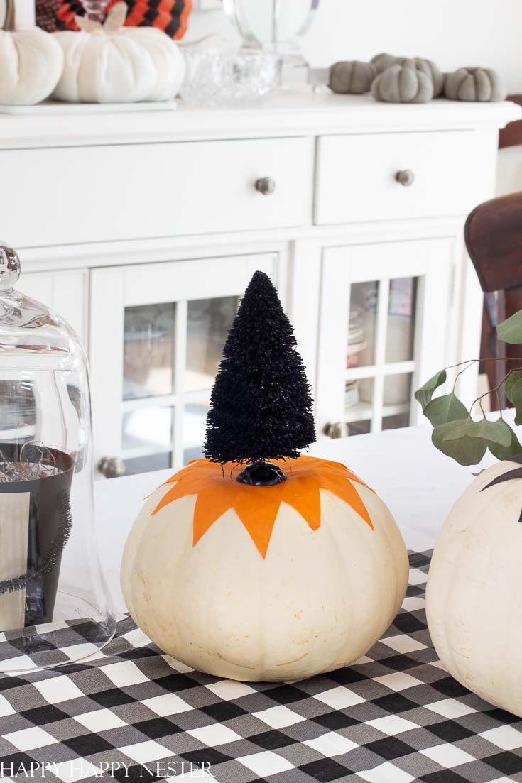 This cute tissue paper pumpkin craft is so easy. You can tack it down with glue or modge podge it to the pumpkin. Top with a cute Halloween bottle brush tree. #halloween #modgepodge #crafts #halloweencrafts #pumpkinideas