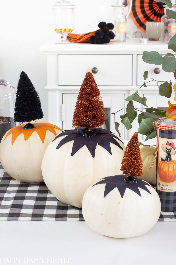 This cute tissue paper pumpkin craft is so easy. You can tack it down with glue or modge podge it to the pumpkin. Top with a cute Halloween bottle brush tree. #halloween #modgepodge #crafts #halloweencrafts #pumpkinideas