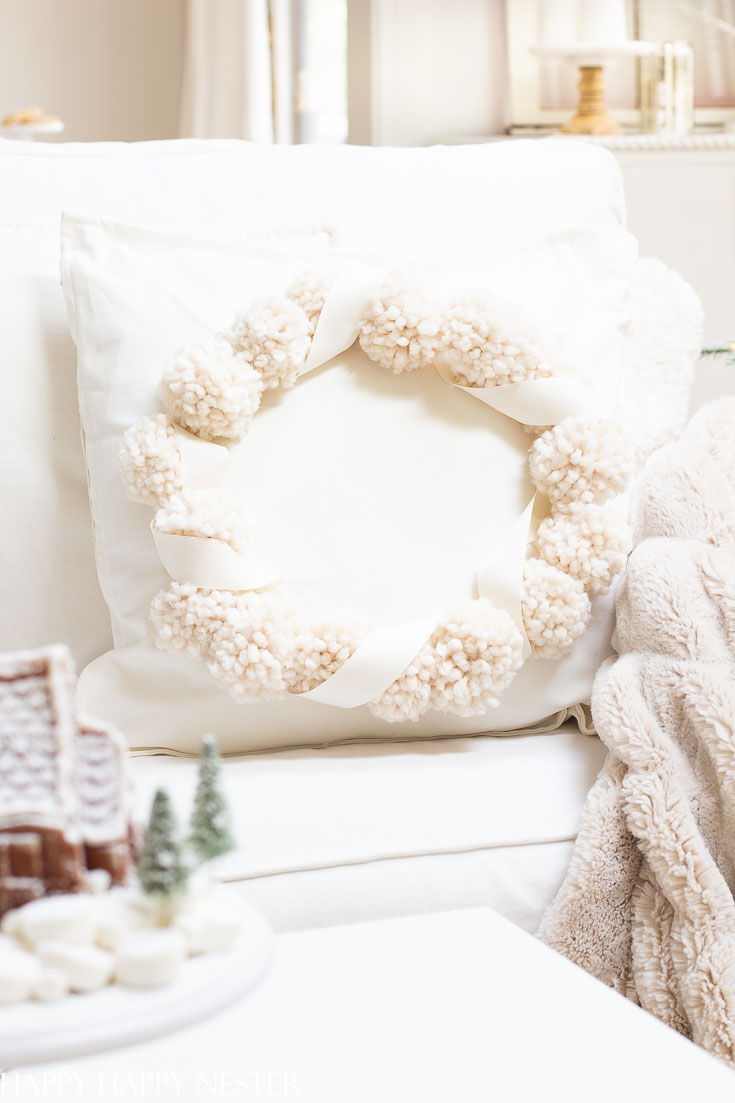 This adorable Christmas Pillow Craft Project is perfect for the holidays. It's an easy project to create and make it in your favorite holiday color. There are 13 pom pom projects in this blog post. #pompoms #crafts #holidaycrafts #pillowproject #pillows #christmas