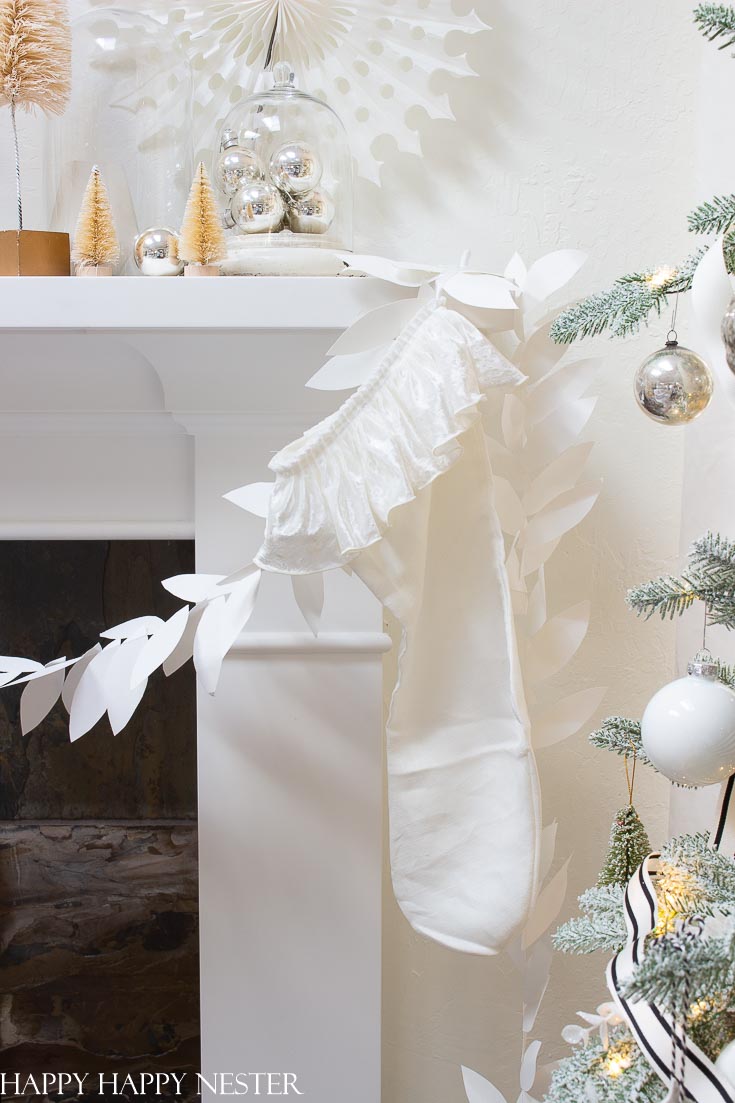 Here is a bright and merry Christmas mantel. The white holiday decor includes two garlands, felt fleece trees, and vintage ornaments. Head on over to see 41 mantels from some very talented bloggers. #christmasmantel #decorateforchristmas #christmasdecor #holidaydecorating