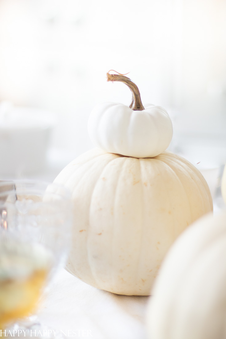 Here is a Thanksgiving Table Setting Made Easy. Find out how the 7 elements to set a Thanksgiving table step by step. White pumpkins are a must when creating a table setting. This table has all-natural elements and wheat makes a beautiful fall centerpiece for a table. #thanksgiving #thanksgivingtable #tabledecor #createathanksgivingtable #tablesetting