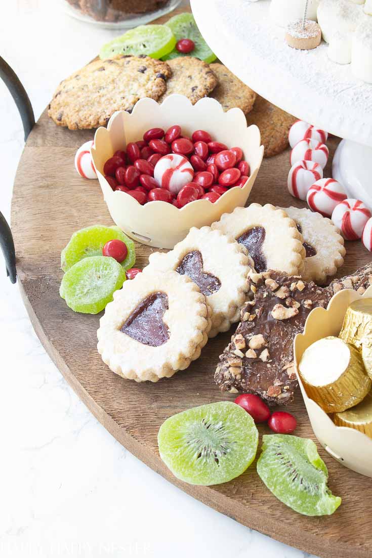 Add your favorite items to create this fun Christmas dessert board. This charcuterie includes my favorite chocolate chip, raspberry heart, and almond cookie recipes. #cookies #christmasdessert #christmascookies