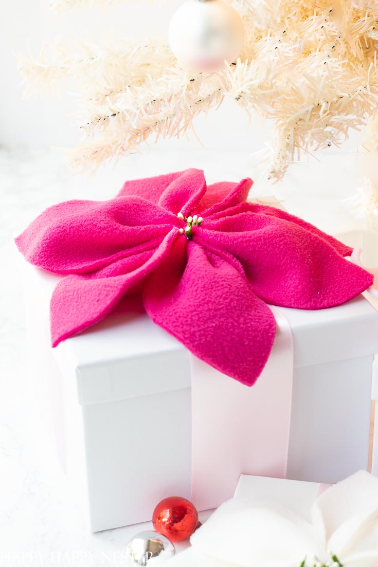 Create this adorable fleece poinsettia for the holidays! Make them in any color you like and place them on your Christmas gifts. #christmasprojects #easyflowers #crafts #flowers #poinsettia #paperflowers 