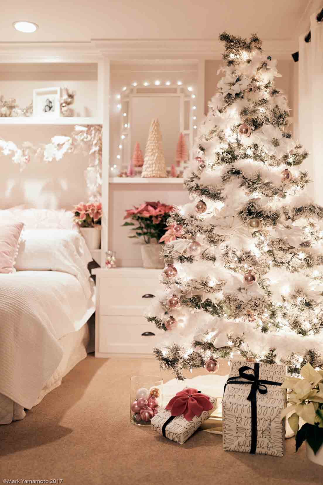 This pink Christmas decor is a winter wonderland. Pink poinsettias, bottle brush trees, and vintage pink ornaments are all the decor used in this holiday bedroom. It is festive, pretty, and feminine and perfect for the long winter nights. #christmas #holidaydecor #decorating