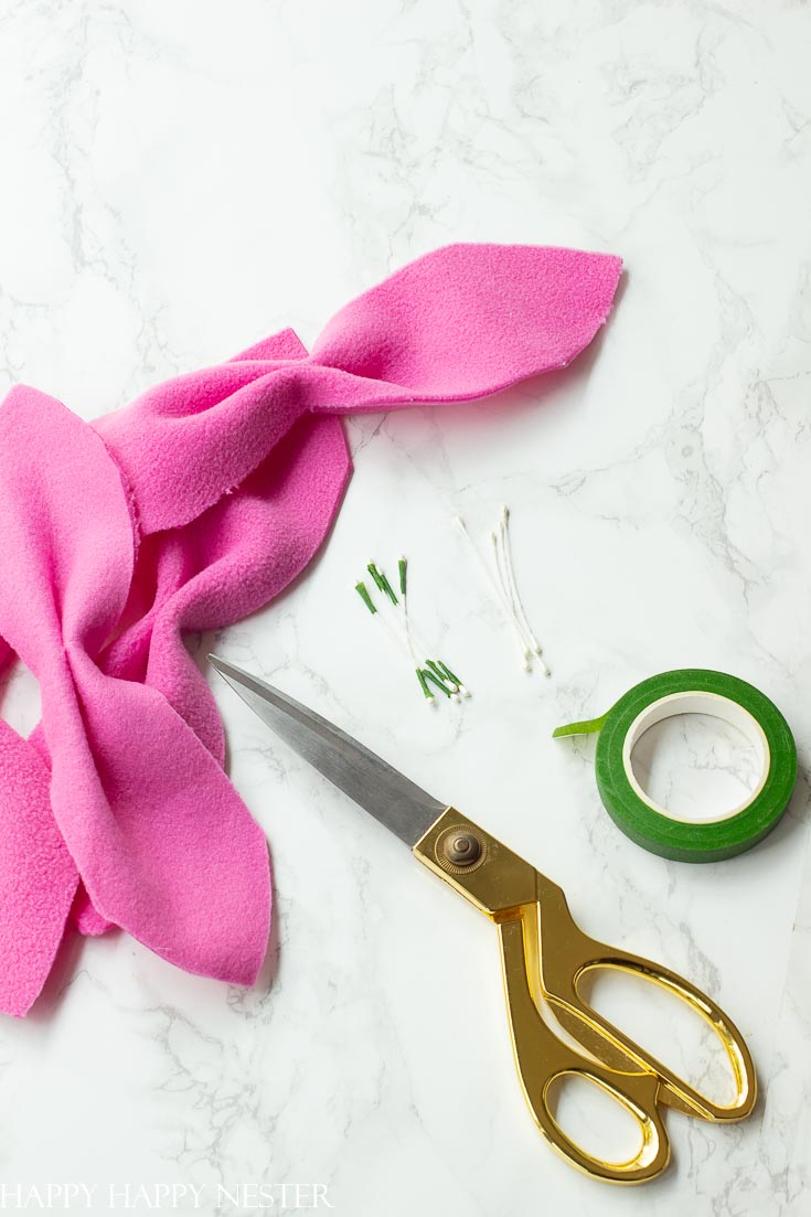 Do you have a bunch of fleece fabric that you would like to use? This poinsettia craft is so easy and cute. Make them and top them on your Christmas gifts. #christmas #poinsettia #flowermaking #paperflowers #christmasproject #giftwrapping